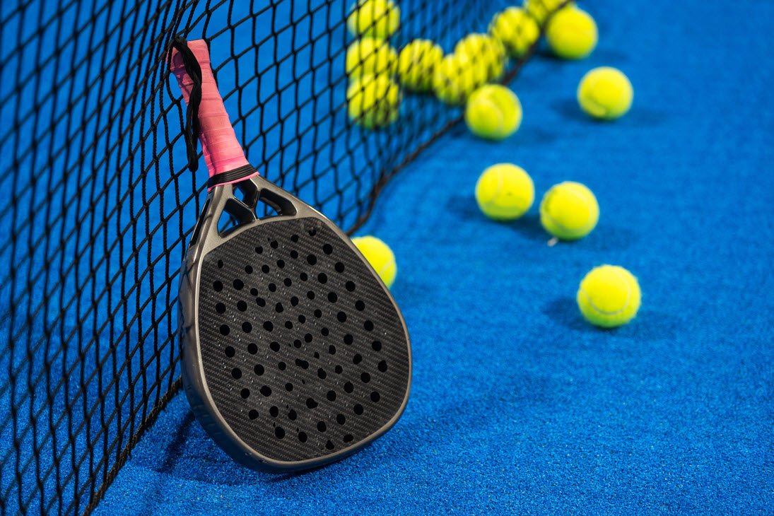 Padelbat og mange bolde på padelbane